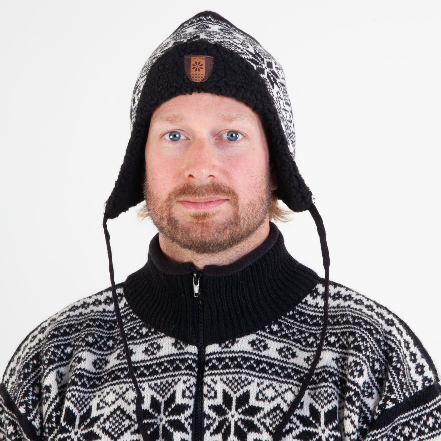 Klassisk lue med klaff og snøre for vindfulle forhold.